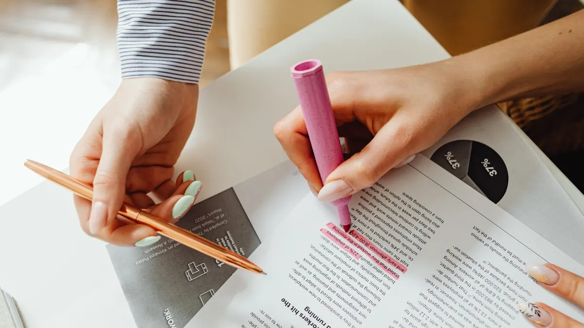hands marking up printed pages with highlighters
