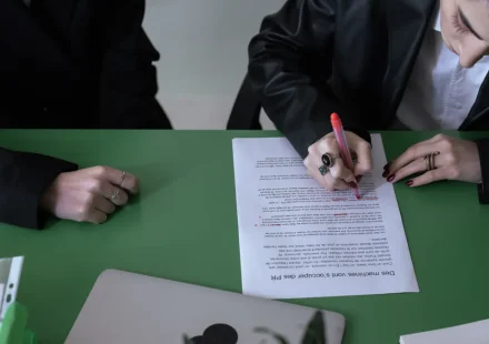 person signing a document at a table
