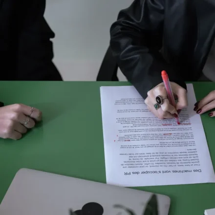 person signing a document at a table