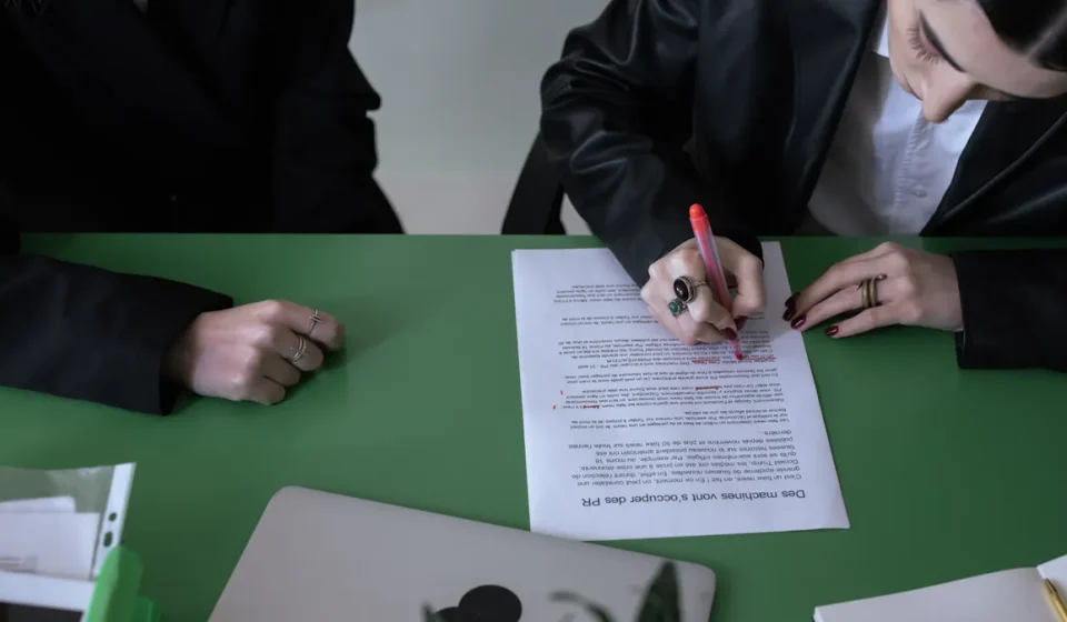 person signing a document at a table