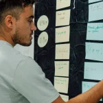 person organizing sticky notes on a planning wall