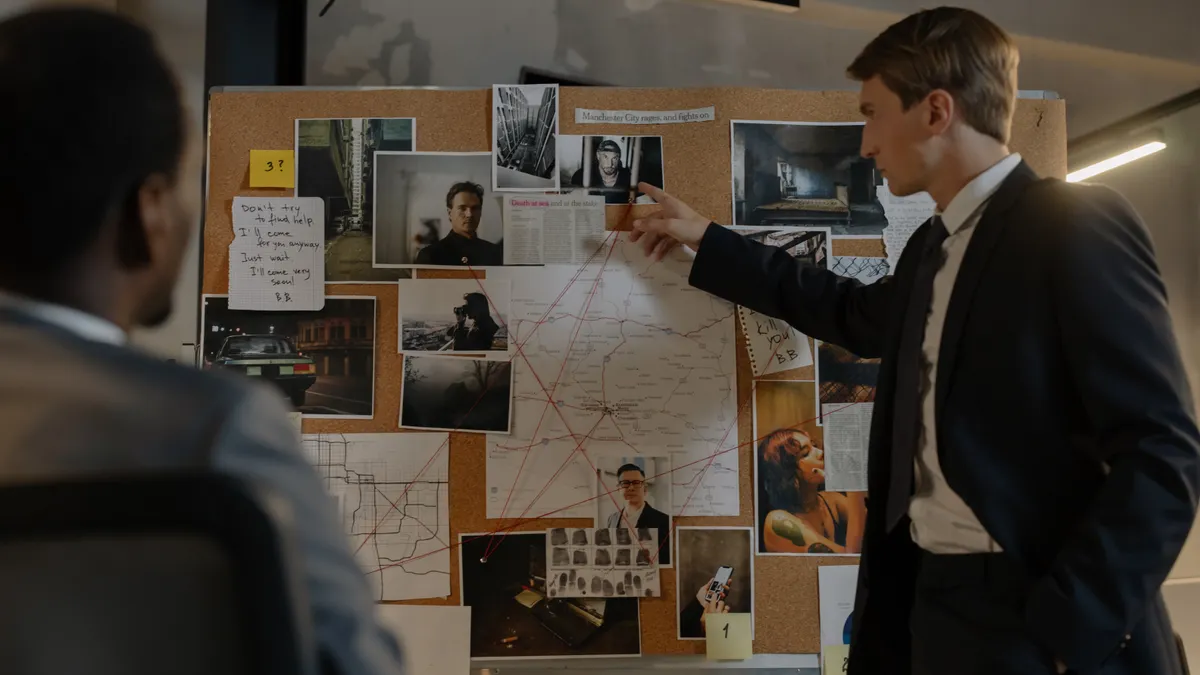 two people studying a photo-and-map strategy board