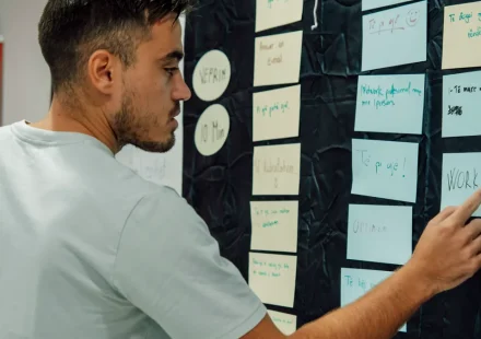 person organizing sticky notes on a planning wall