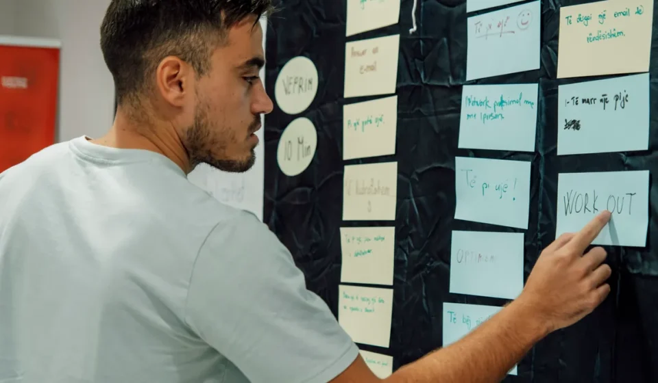 person organizing sticky notes on a planning wall