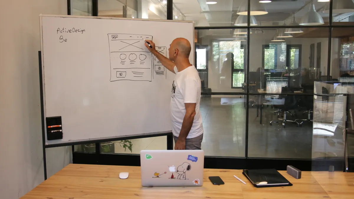 How to Structure Service Pages for Bing AI Discovery Person presenting a wireframe sketch on a whiteboard