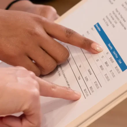 Hands pointing at a printed pricing table